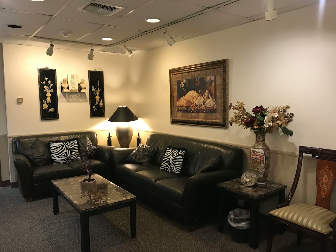 Waiting room with leather seating, framed art, and warm lamp light