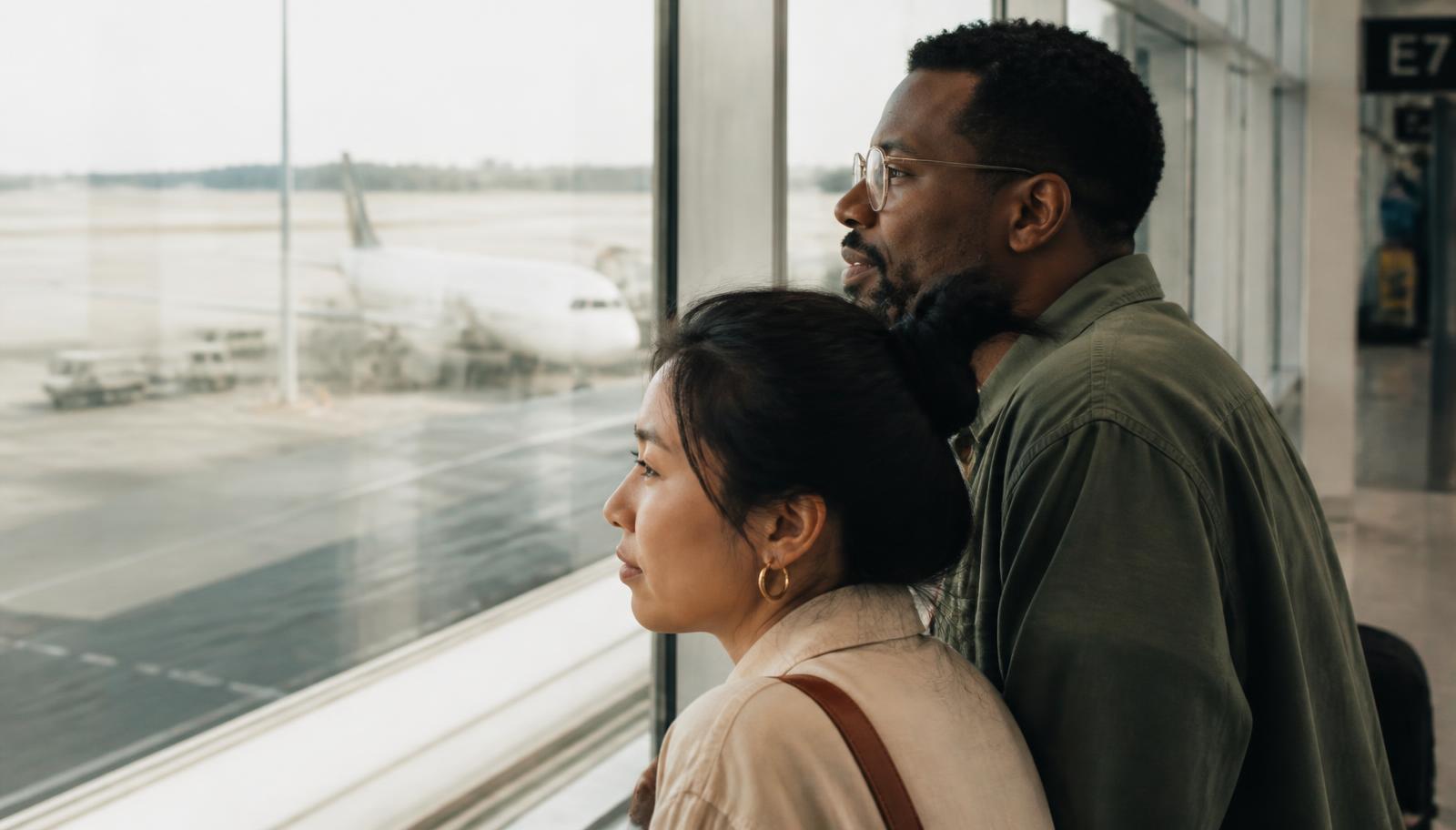 Couple watching planes from an airport window