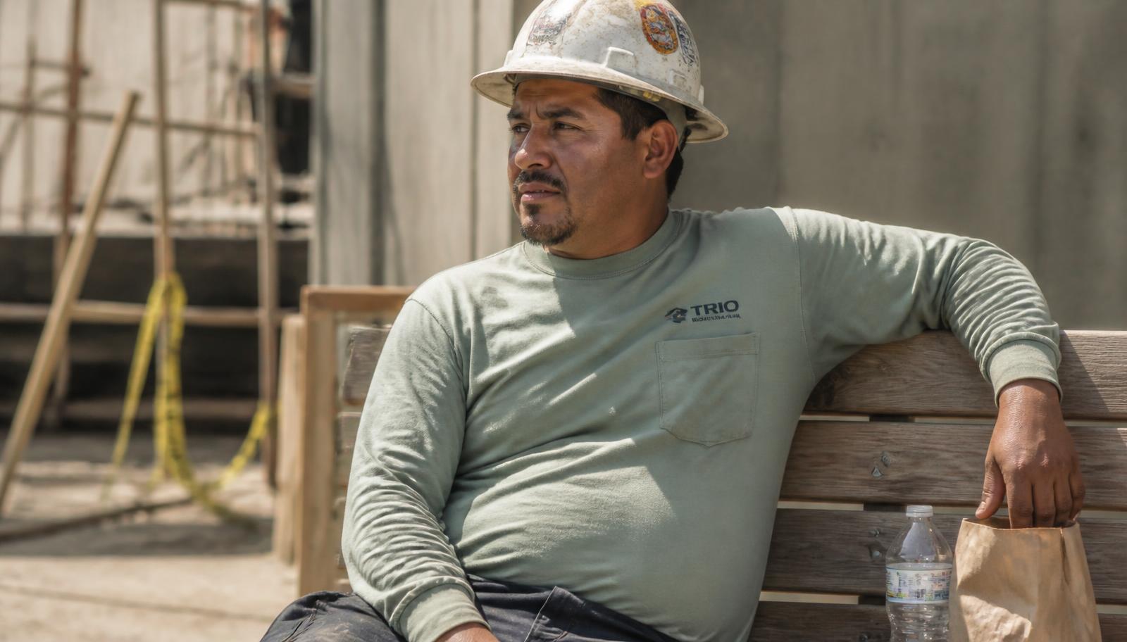 Construction worker resting on a bench in the sun