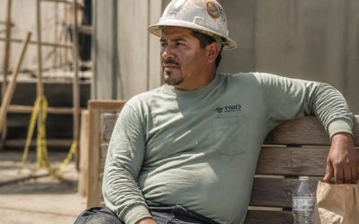 Construction worker resting on a bench in the sun